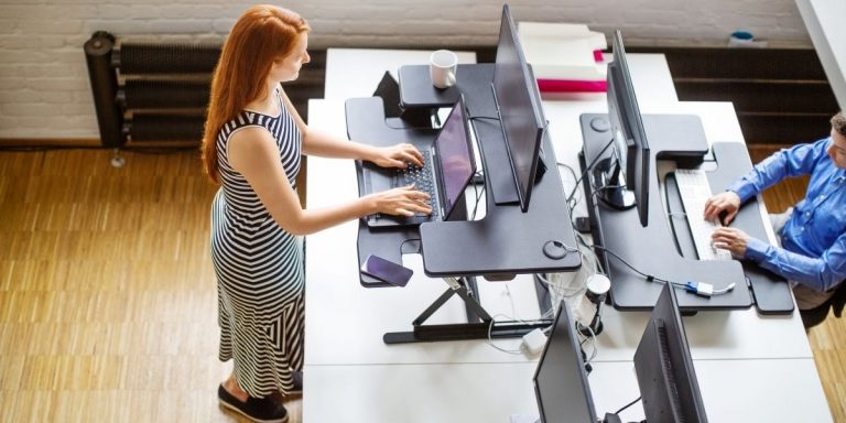 Woman Standing At Her Desk Typing